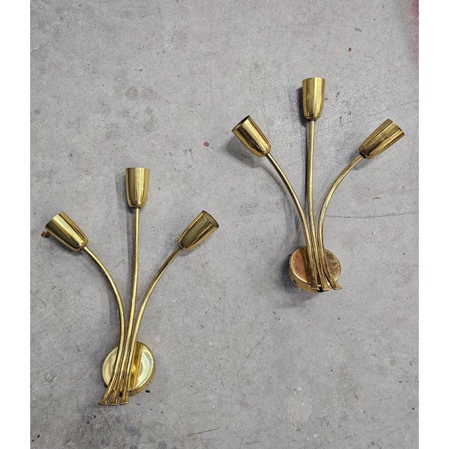 In this listing you will find a pair of floral Mid Century Modern Sconces done in brass. The 3-arm sconces are very simple...