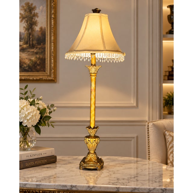 Table lamp with an ornate gold-tone base with urn and foliate motifs, and a tailored fabric shade trimmed with crystal-...