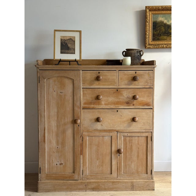 A Victorian stripped pine compactum in an asymmetric layout — a full-height wardrobe with an arched raised-panel door to...