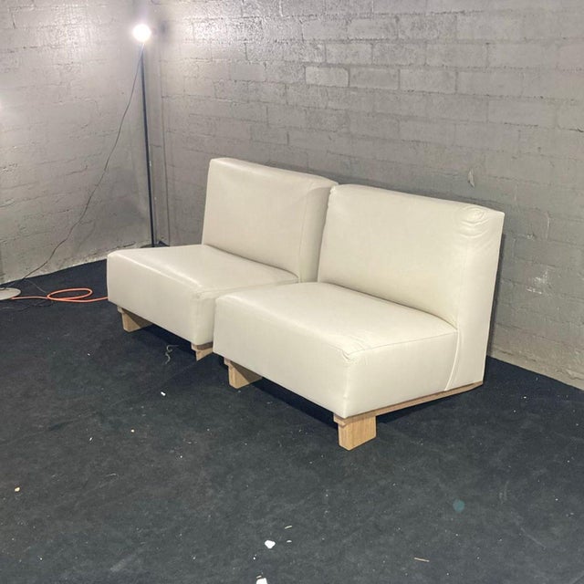 This set includes two modern armless lounge chairs in a clean white finish. Each chair features a soft, comfortable seat...