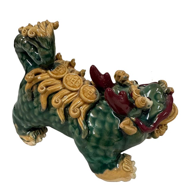 The figurines in the image are a pair of Chinese Feng Shui Prosperity statues, Foo Dogs (Guardian Lions), or Dragon-Headed...