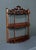 This elegant wall shelf is distinguished by its deep-toned mahogany wood and openwork sculptures. with its three vibrant...