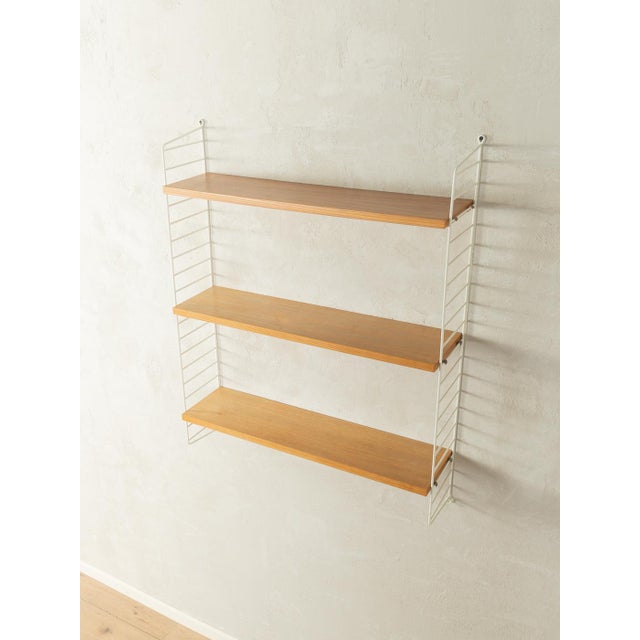 Original String shelving unit designed in 1949 by Nils Strinning in ash veneer. The system consists of two white metal...