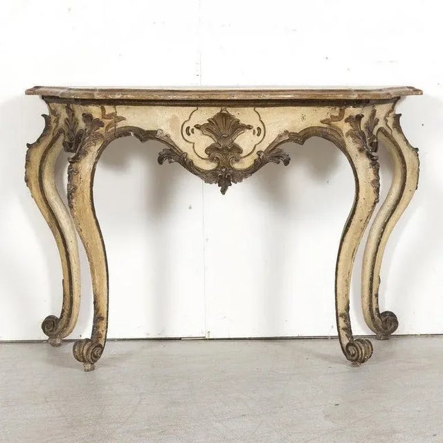 An elegant 19th century Italian Rococo style hand carved polychrome painted and parcel giltwood console table, circa...