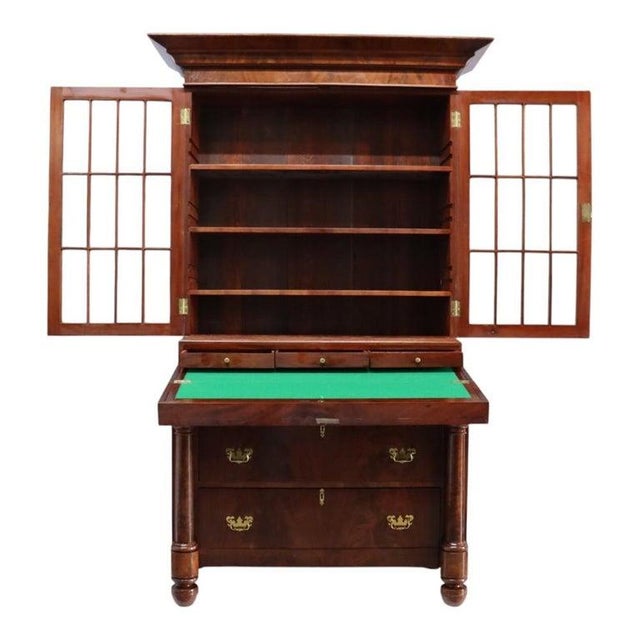 An antique American Empire secretary desk, attributed to Quervelle, crafted from flame mahogany and dating to...