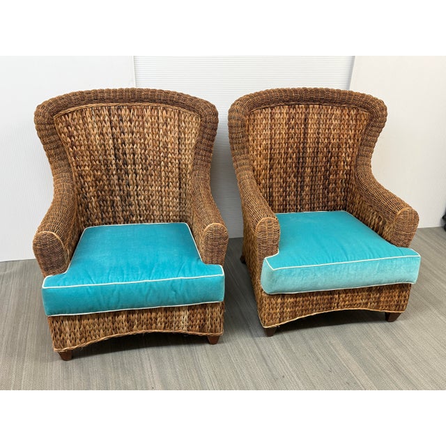 Design Plus Gallery presents a Pair of Vintage Rattan Wingback Chairs. The chair shave a natural woven frame with...