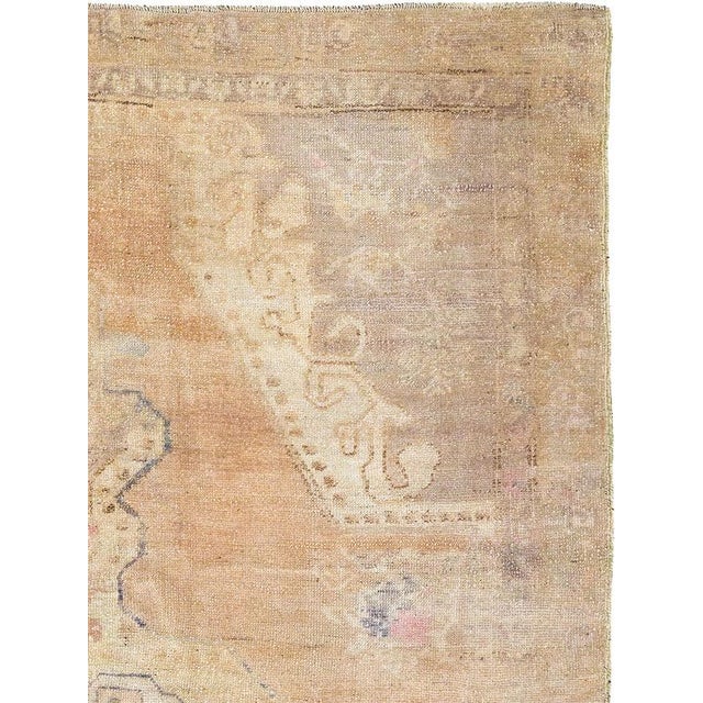 This mid-20th-century Turkish Anatolian accent rug presents a softly balanced composition centered on a large, vertically...