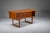 Elegant freestanding danish teak desk from the 1960s featuring distinctive raised lip edges and a fully finished back,...