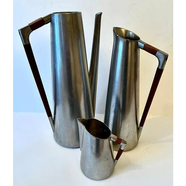 Set of Three Pewter and Teak Pitchers. The measurements for the large pitcher are in the description. The medium sized is...