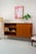 A beautiful teak highboard from the 1960s, immediately striking thanks to its slender, black hairpin legs. The warm brown...
