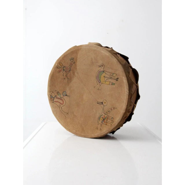 This is a vintage leather drum. A softened, distressed suede leather stretched over the wooden frame shapes the drum with...