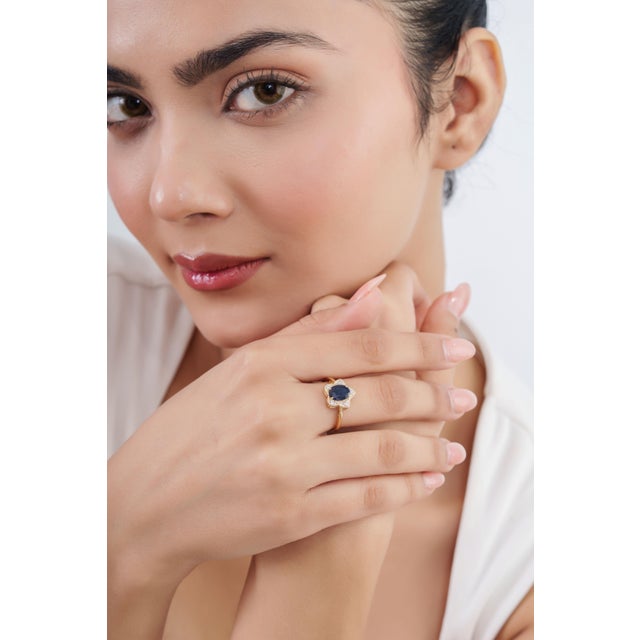 This star cluster ring features a 1.3-carat deep blue oval-cut blue sapphire, set in 14k yellow gold. The center stone...