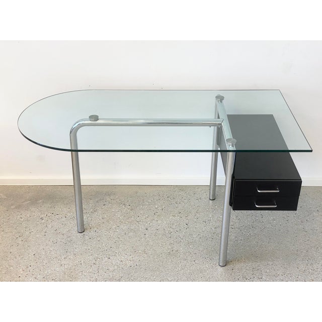 A desk * Elegant and timeless design * 16 mm thick glass top with beveled edges * Chrome-plated tubular steel frame * with...
