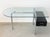 A desk * Elegant and timeless design * 16 mm thick glass top with beveled edges * Chrome-plated tubular steel frame * with...