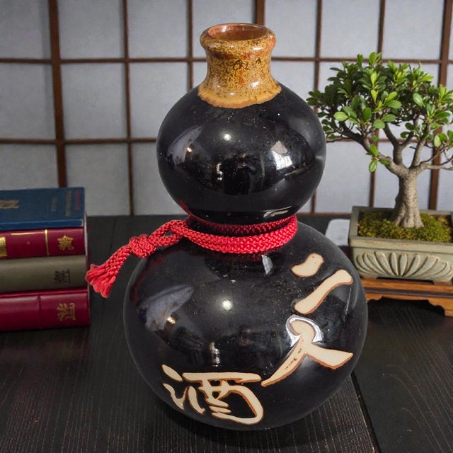 This Asian Japanese Brown Pottery Sake "Tokkuri" Gourd Shaped Decanter is a unique and traditional piece of Japanese...