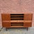 1960s Danish Modern teak highboard by Johannes Andersen. This large storage cabinet has sliding doors throughout, four...
