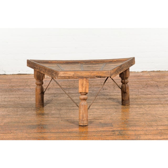 An antique rustic Indian handmade coffee table from the 19th century with trapezoidal top, iron stretchers, turned...
