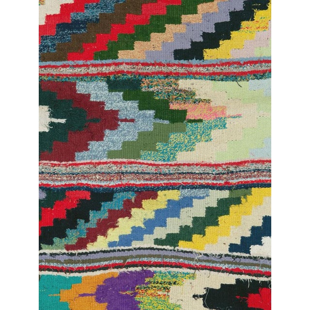 A dynamic Mid-20th century Persian flatweave kilim distinguished by its bold, horizontal bands of zigzag and stepped...