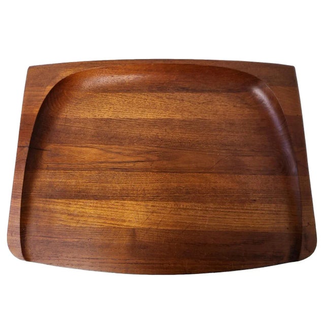Offered is a rather rare and symmetrical, thick, rectangular and slanted staved and lathed Teak wood carving board and...