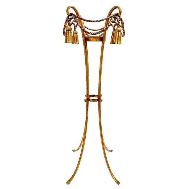 Hollywood Regency style 1960s Italian Florentine gilt rope and tassel plant stand. Standing a whopping 44.5" tall, this...