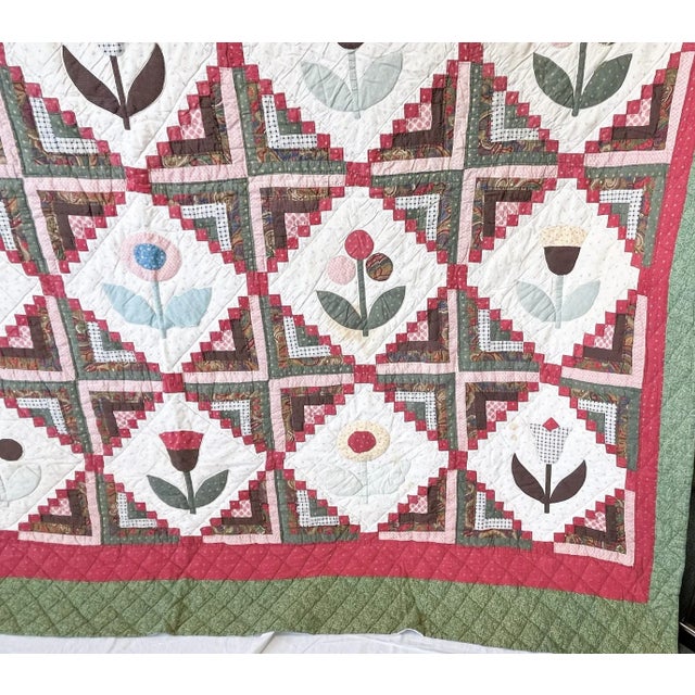 Pretty vintage handmade quilt from the late 20th century. It's made in an American Folk Art style with twenty squares...