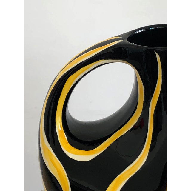 A "tigris" pitcher or vase, modernist, from forme-libre, sensual body in thick glossy black enameled ceramic decorated...