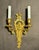 A refined pair of early 20th century French gilt bronze wall sconces in the Louis XVI style, distinguished by their...
