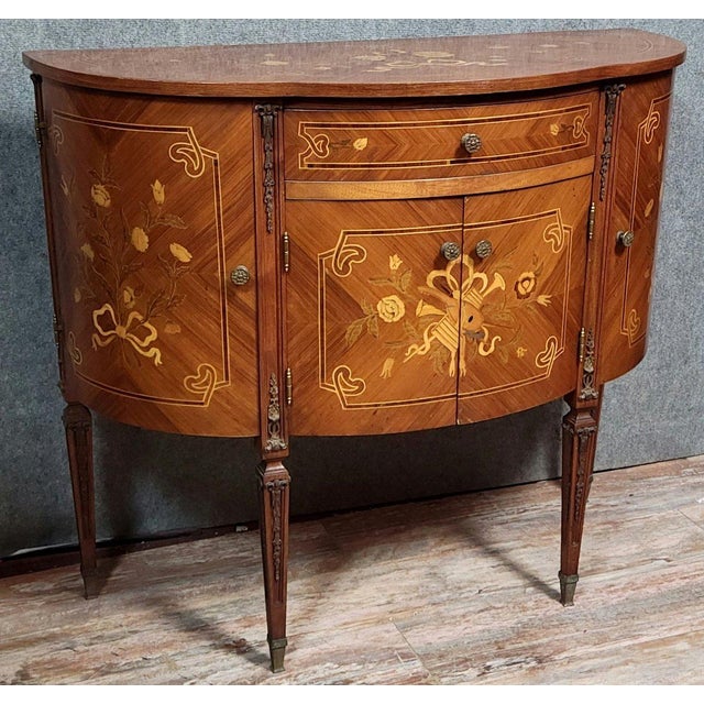 A 20th-century venetian commode with a half-moon shape and doors, in the louis xvi style, featuring marquetry. The front...