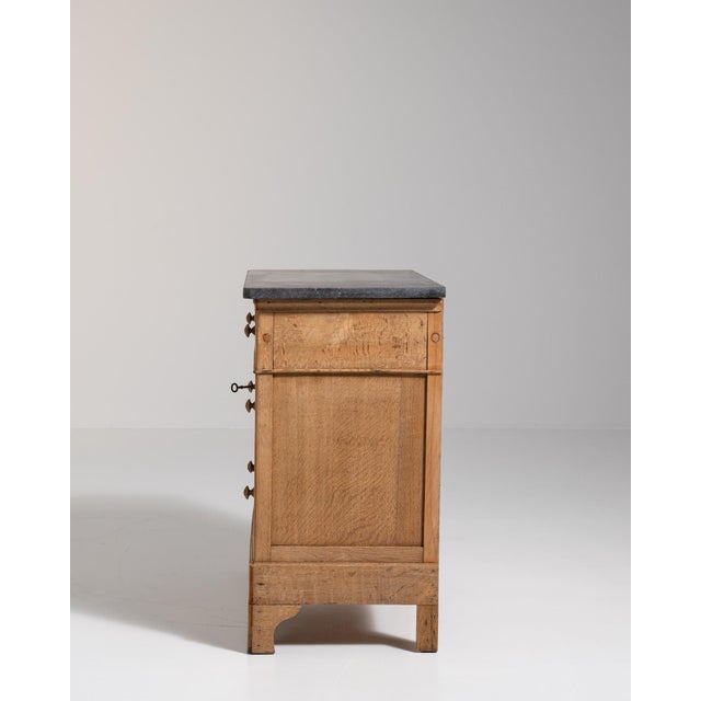 A brown wood, French Provincial-style chest of drawers from the 1900s, made in France. Crafted in wood with stone...