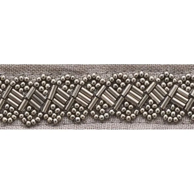 A narrow tape embellished with a delicately beaded braid design, Opsius Trim adds texture and sophistication to wherever...