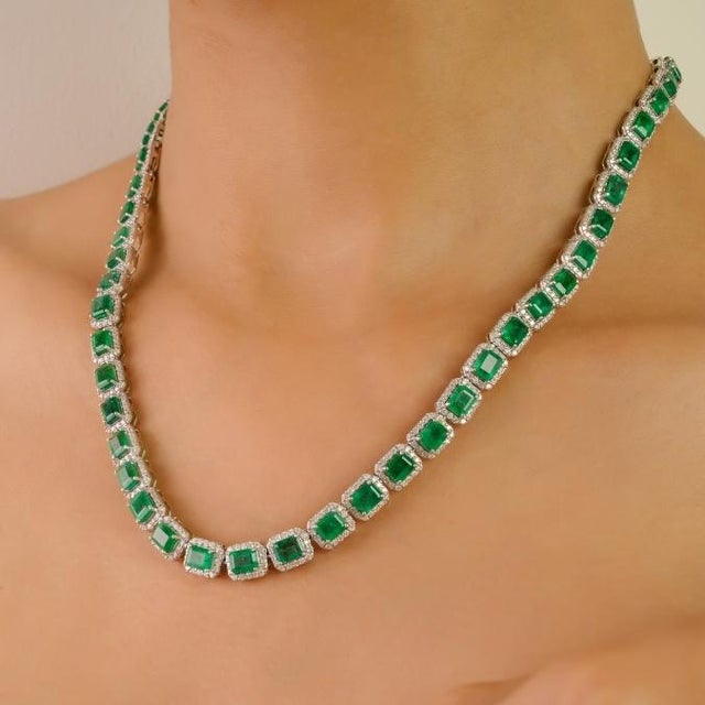 This luxurious 14K white gold tennis necklace features 54 octagon-cut emeralds totaling 24.47 carats, elegantly framed by...