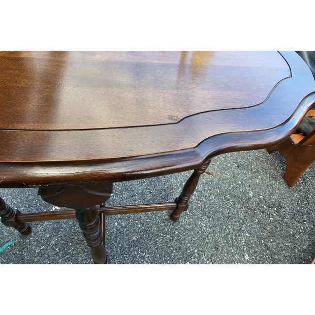 This Walnut Edwardian side table featuring four turned legs, cross bars at bottom and and carved top. No maker's mark....