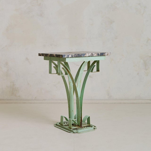 A 1930s French Art Deco side table, defined by a breccia marble top and celadon green iron base. The rectangular slab is a...