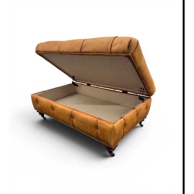 Vintage Ralph Lauren Brierly Ottoman in classic camel leather on turned mahogany legs on brass casters. The ottoman has a...