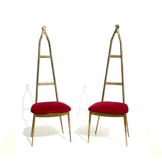 These rare brass chairs have red velvet upholstery.