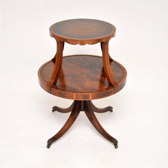 A beautifully made antique two tier table with a leather top. This is in the Regency style, it dates from around the...