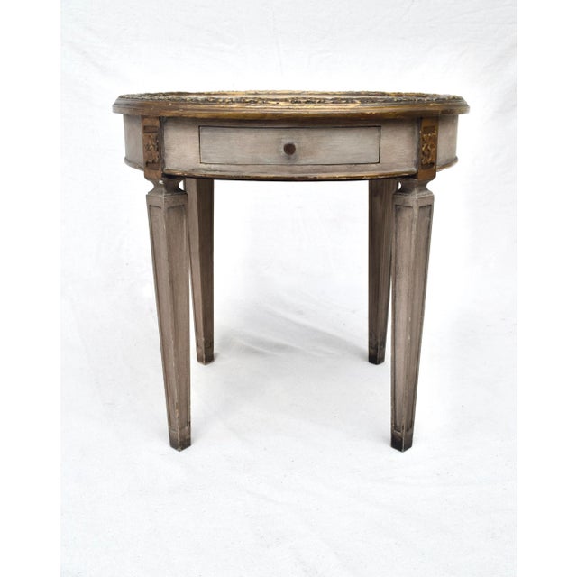 Directoire style Verre églomisé round parcel gilt occasional table with single dovetail drawer. Charmingly suitable for a...