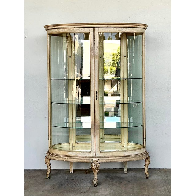 Elevate your interior with this exquisite vintage French-style display cabinet, featuring a graceful bow-front silhouette...