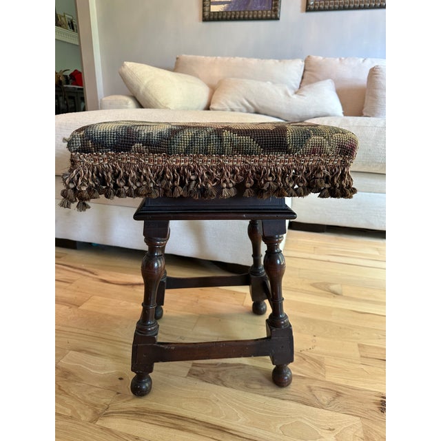 Solid oak footstool featuring traditional pegged mortise-and-tenon construction, turned legs, and stretcher base....