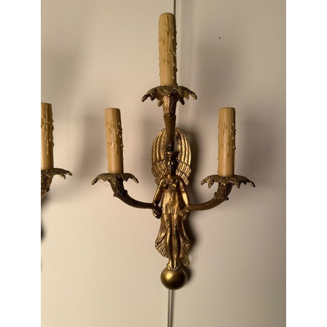 Pair of late 19th-century French Neoclassical style bronze wall sconces featuring angel figures with three-arm...