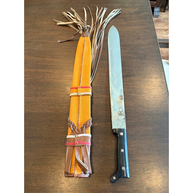 Vintage Colombian Machete Knife Garza #66 with leather fringe sheath. Sheath is ornately stitched and decorated with red,...