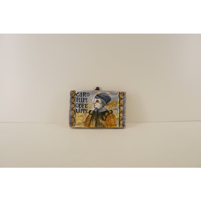 This hand-painted Castelli maiolica portrait tile reflects Italy’s long ceramic tradition, depicting a classical...
