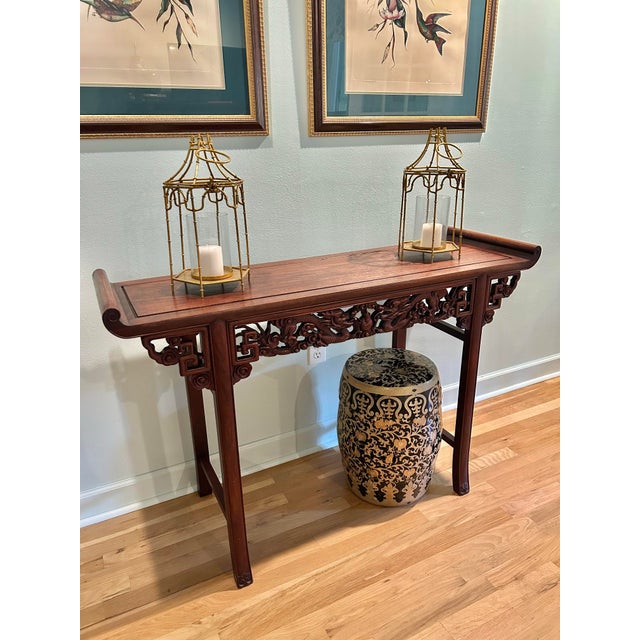 This rosewood altar table has all of the features. Heavily carved, the upturned flanged ends frame an apron with dragons...