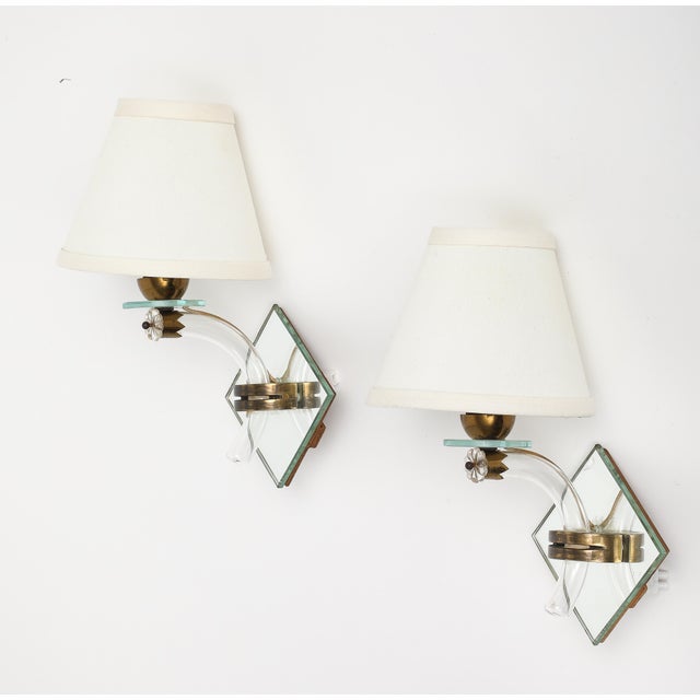 Pair of midcentury French mirrored sconces with blown glass and brass fittings. Adorned with a flower detail just below...