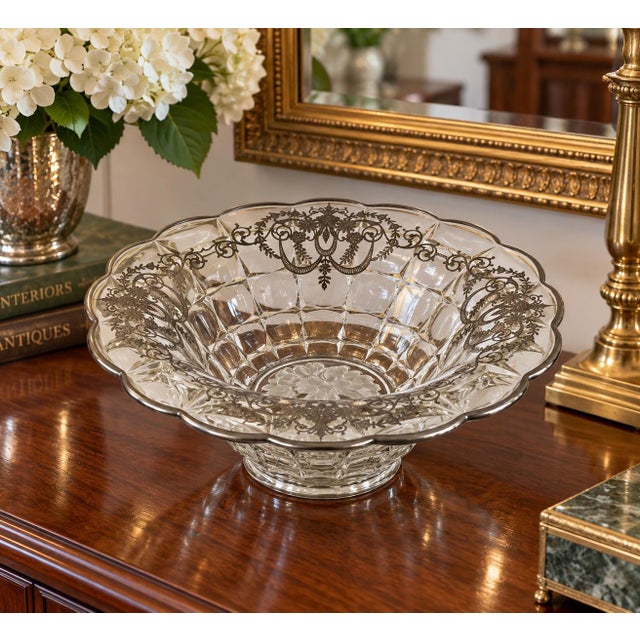 Elegant vintage clear pressed glass centerpiece bowl featuring an elaborate silver overlay decoration and a silver-trimmed...