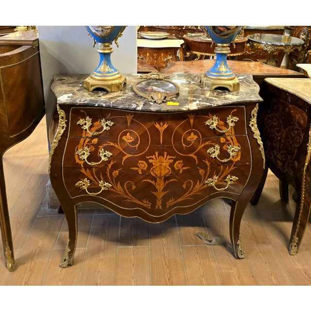Make a statement with this magnificent French bombe commode, showcasing exceptional floral marquetry, graceful serpentine...