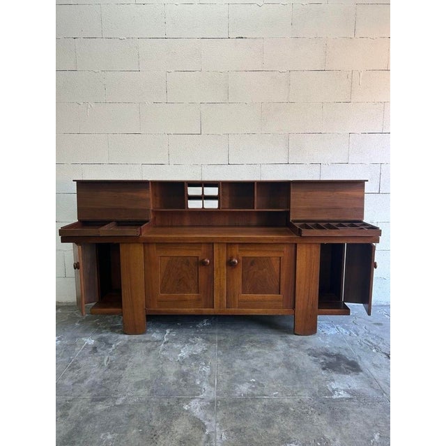 Walnut sideboard with fine finishes, featuring clean and elegant geometric lines. The structure consists of an upper...
