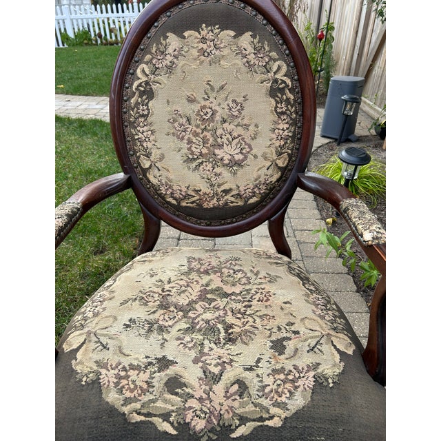This is an antique parlor tapestry armchair with a carved mahogany frame and floral tapestry upholstery. Likely made by S....