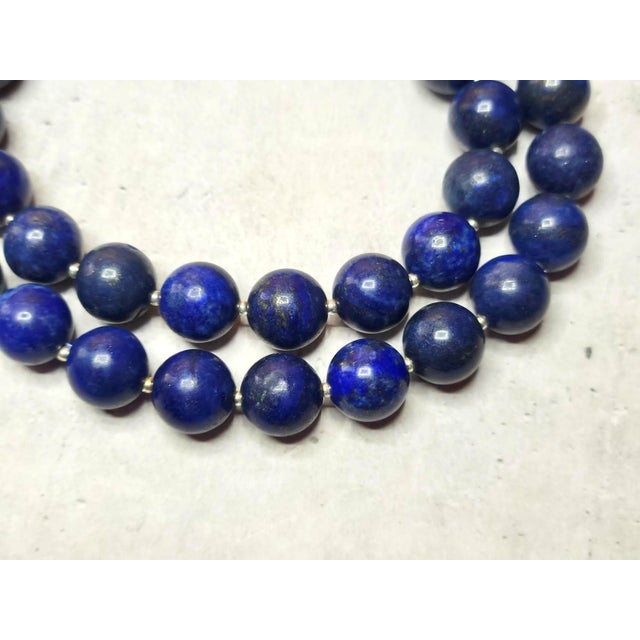 The necklace is 17.5 inches (44.5 cm) long, and the smooth round beads are 12 mm in size. The lapis lazuli beads are dark...
