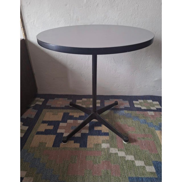 Charles and Ray Eames contract base bistro table with a light purple-grey or taupe circular top. The style of the label...